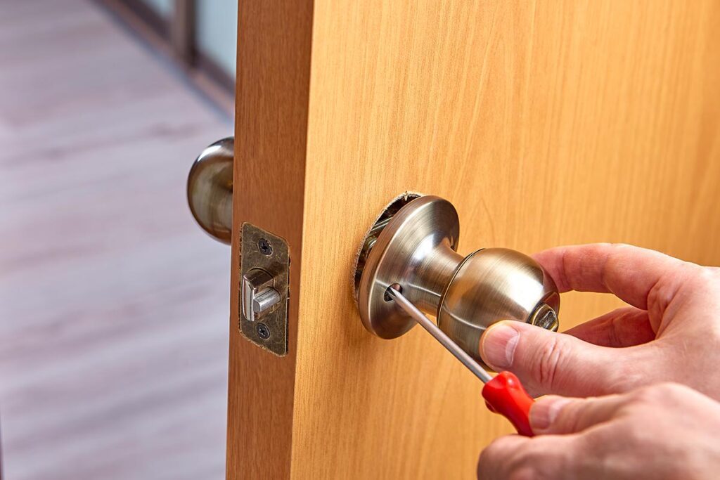processus d'installation d'une nouvelle serrure sur une porte d'entrée avec kit d'outillage
